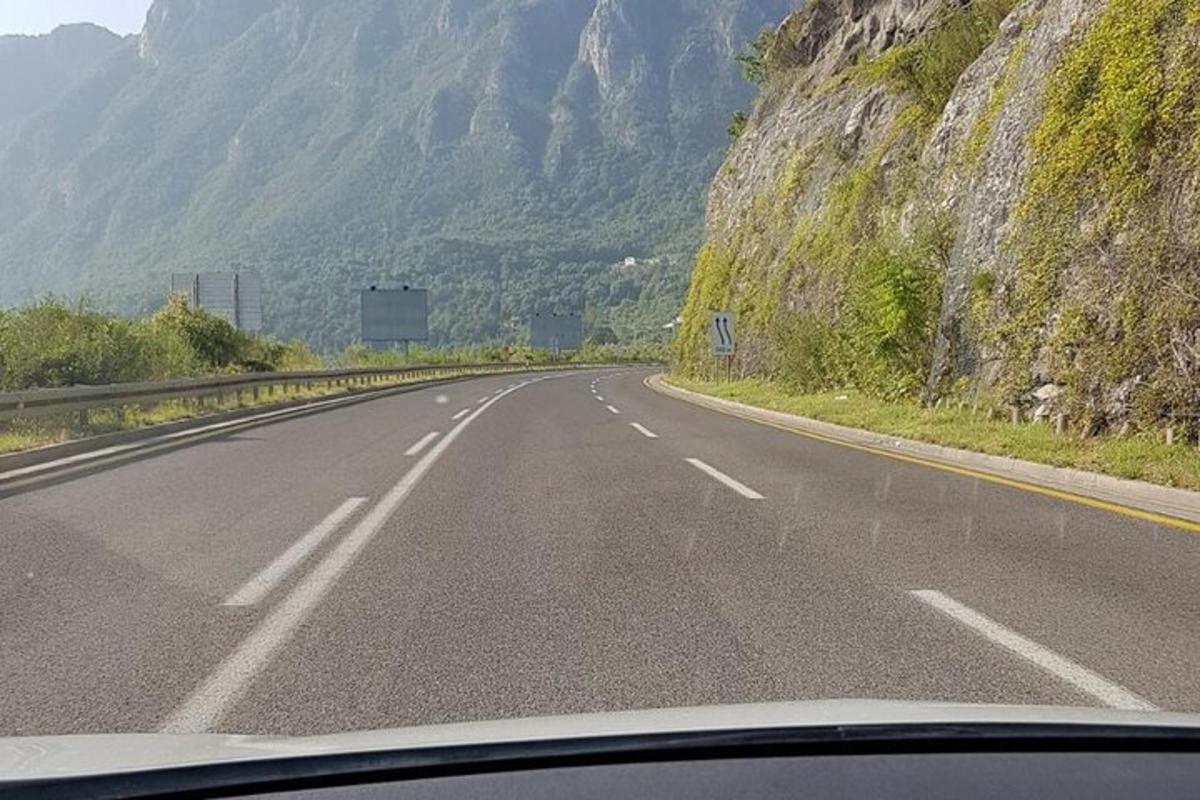 pogled skozi vetrobransko steklo na cesto z gorami