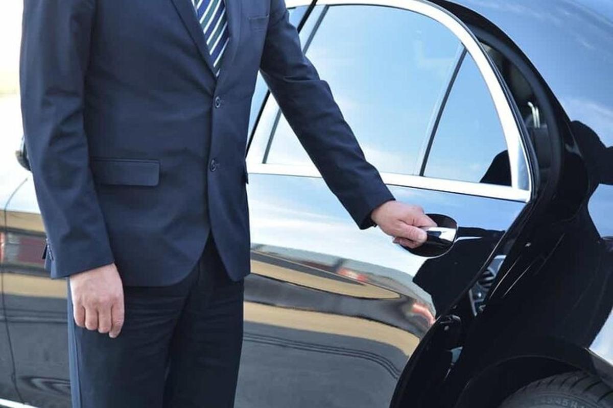 ein Mann im Anzug öffnet eine Autotür