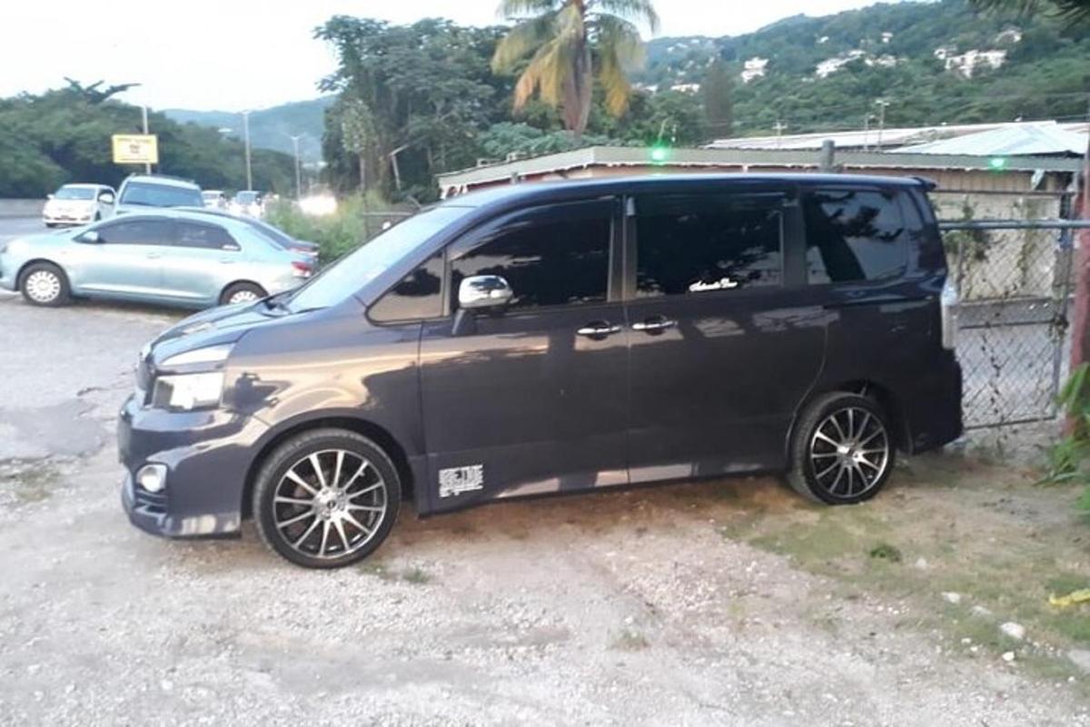 juodas mikroautobusas, pastatytas prie tvoros