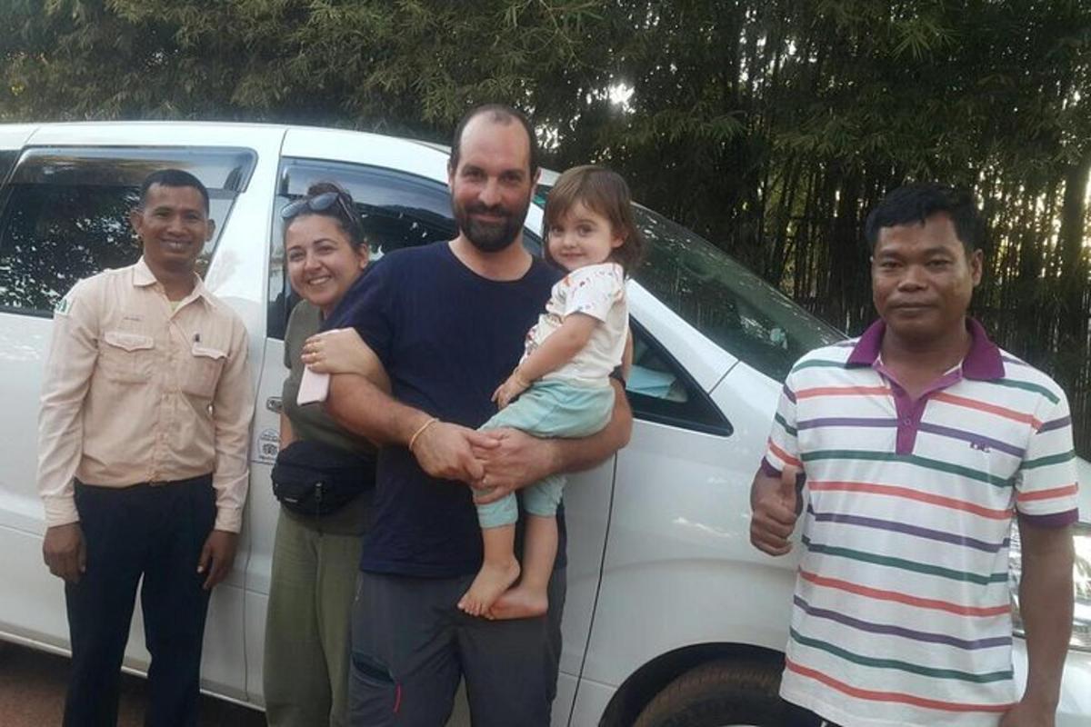 a group of people standing in front of a car