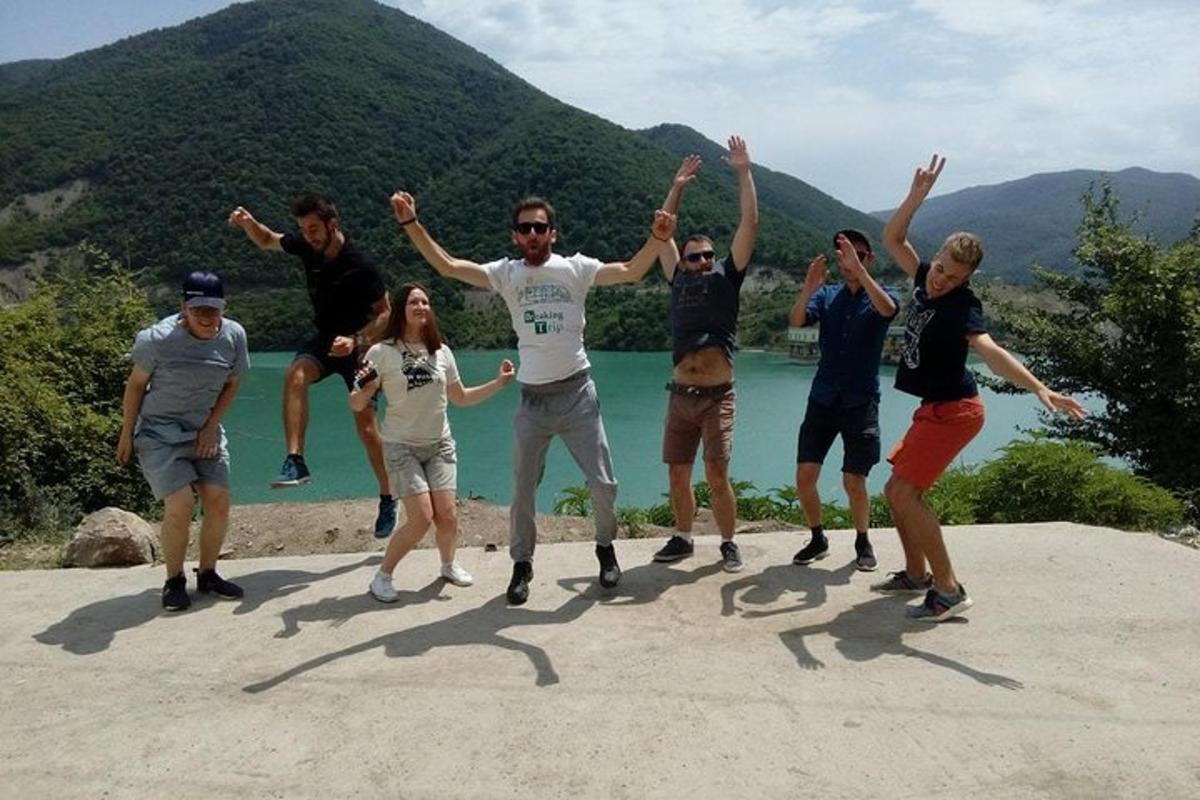 a group of people standing on a rock with their arms up