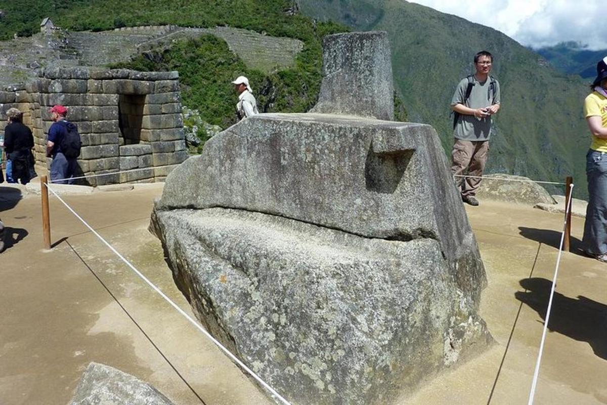 Un grupo de personas de pie alrededor de un monumento de piedra.
