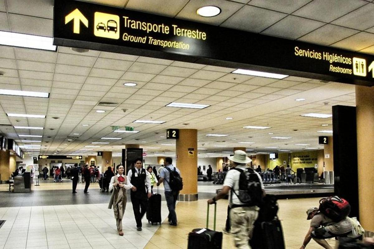 a group of people walking through an airport with luggage