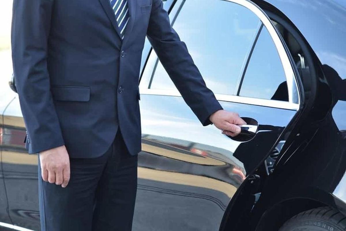un bărbat în costum coboară dintr-o mașină