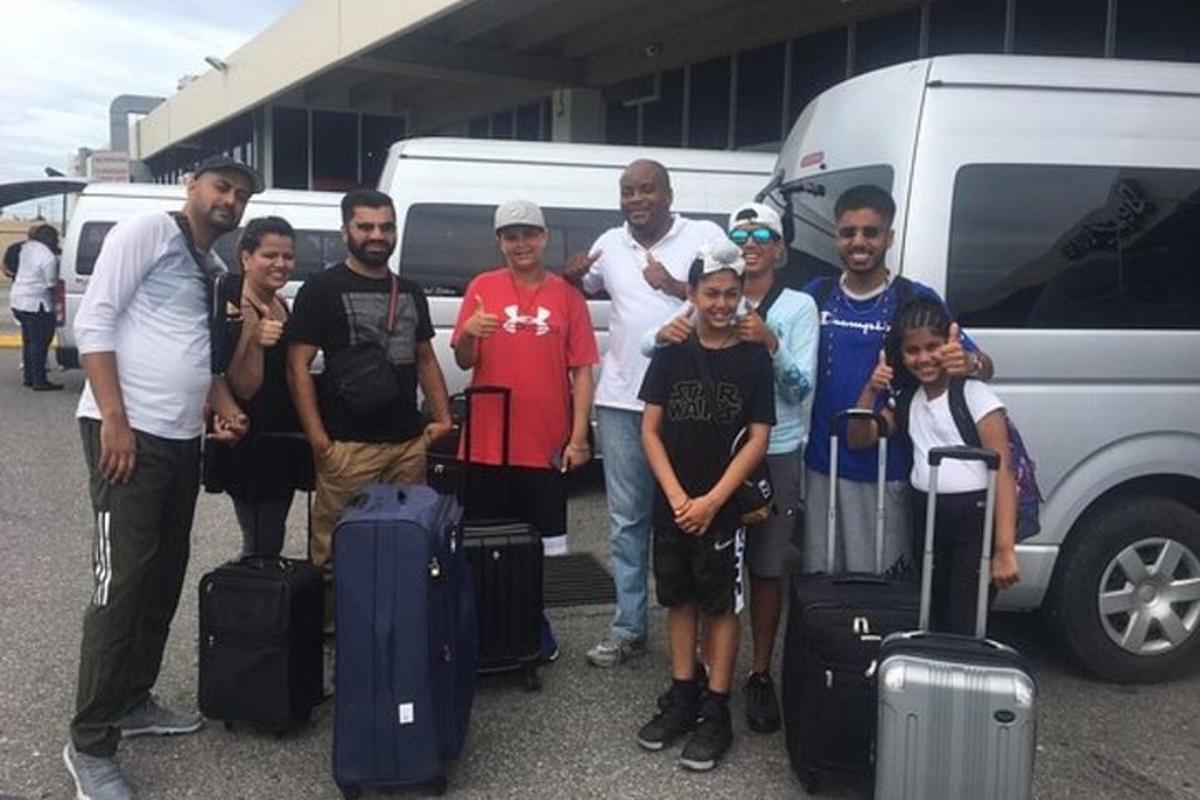 Un grupo de personas de pie junto a una camioneta con equipaje.
