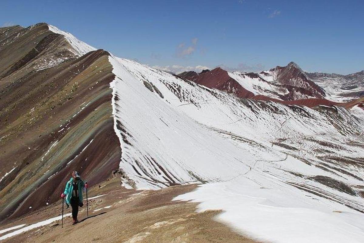 una persona che sale su una montagna coperta di neve