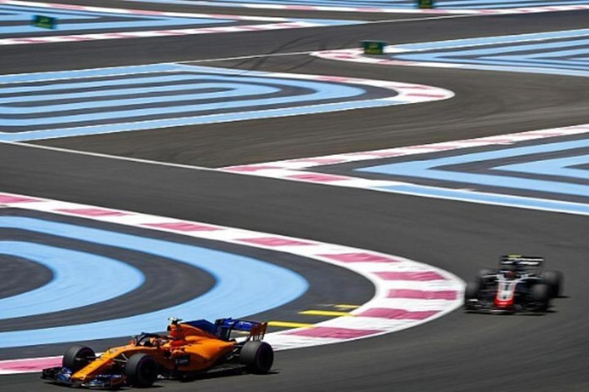 dois carros de corrida correndo em uma pista de corrida