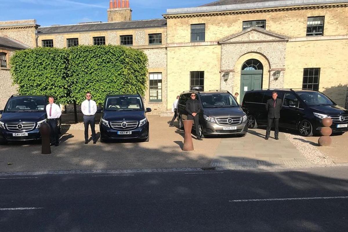 a group of people standing in front of parked cars
