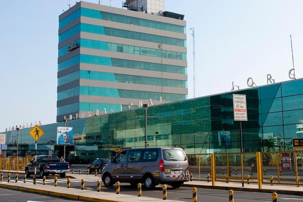 un grande edificio di vetro con le auto che gli passano davanti