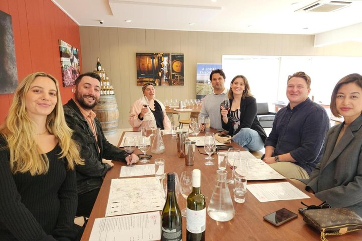 a group of people sitting around a table with wine bottles