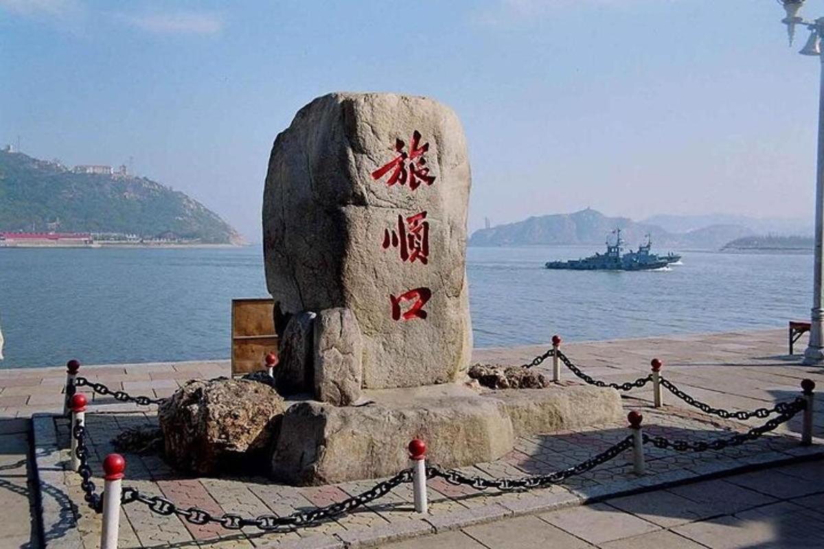 a stone monument with writing on it next to the water