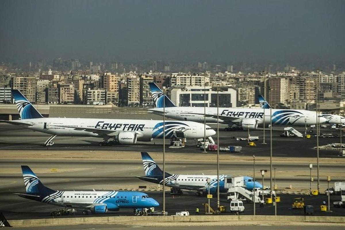 um grupo de aviões estacionados na pista de um aeroporto