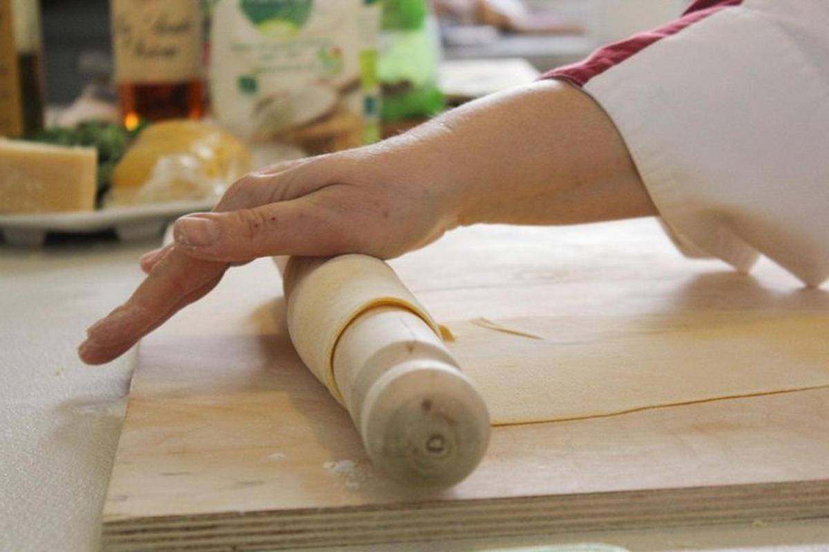 uma pessoa segurando uma cenoura em uma tábua de corte