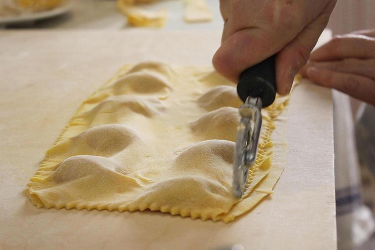 osoba krájející těsto kráječem pizzy
