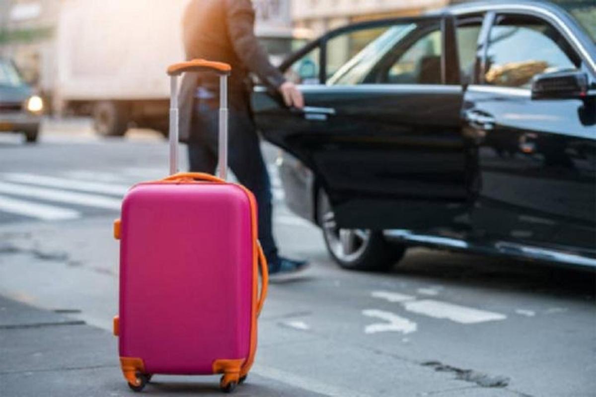 une personne tirant une valise rose dans la rue