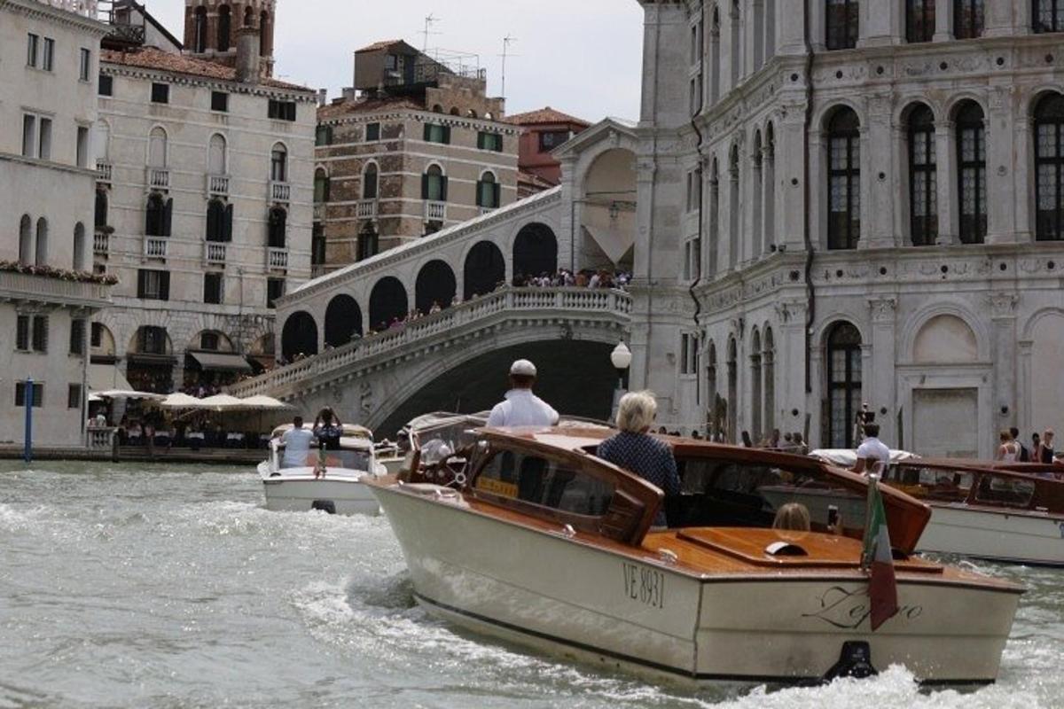 una barca in acqua davanti a un ponte