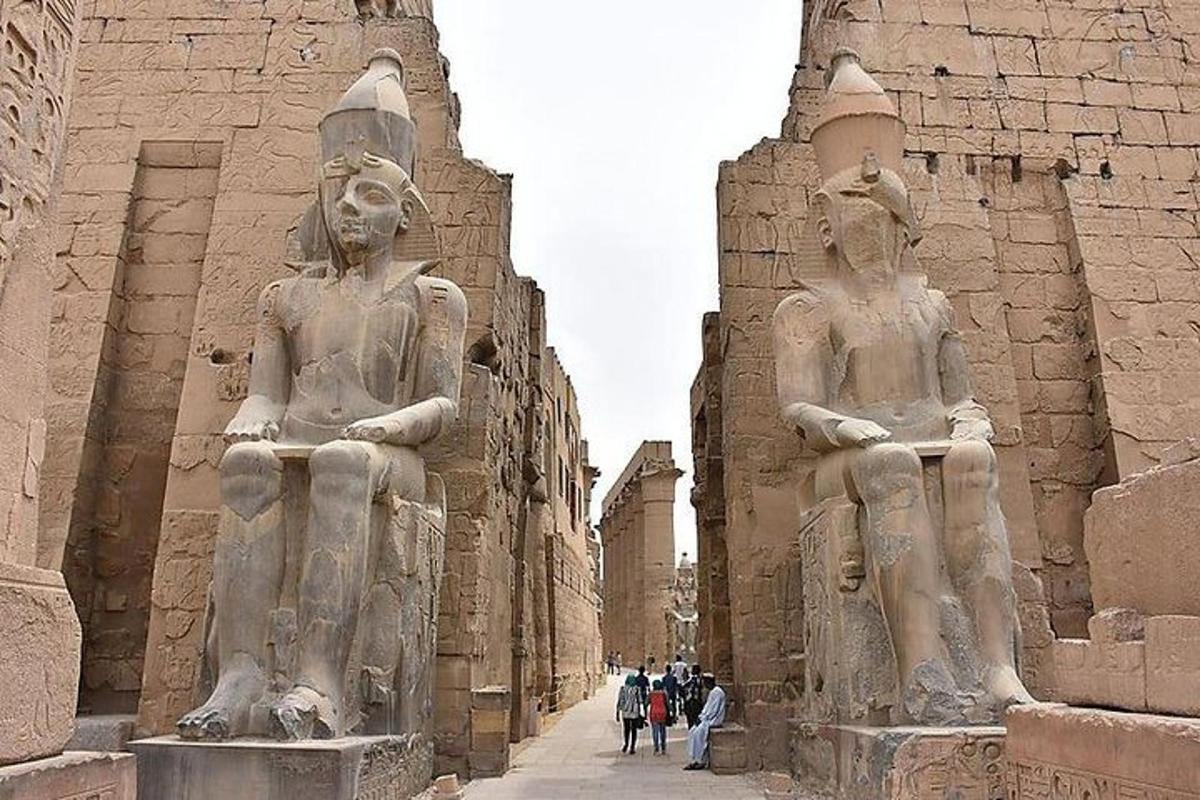 statuju grupa, kas stāv blakus ēkai