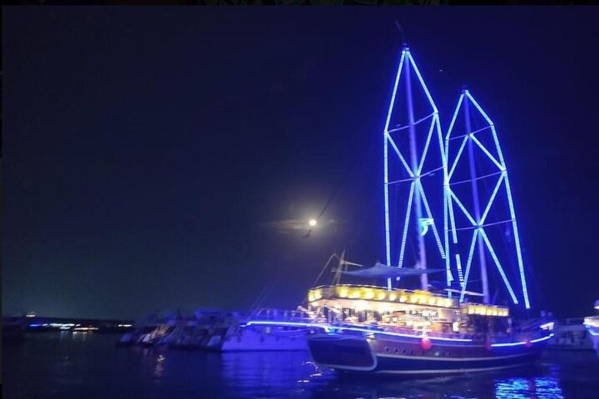 um barco com luzes na água à noite