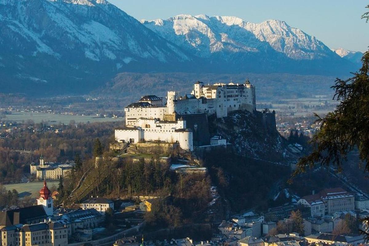 hrad na vrcholu kopce se zasněženými horami