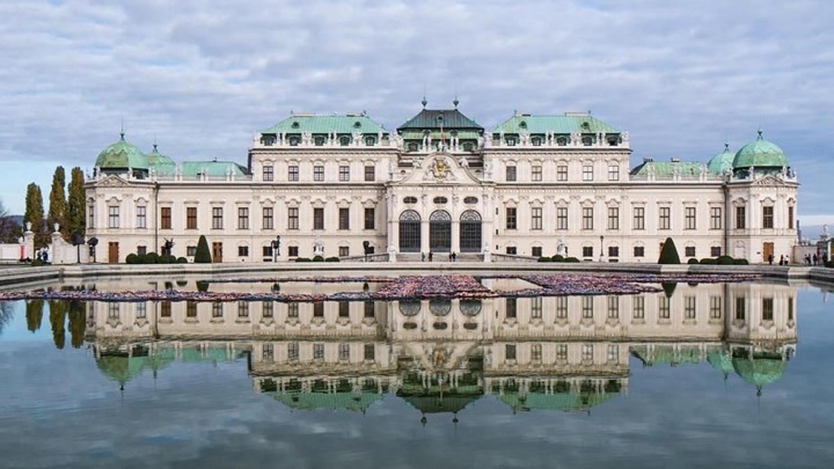 en stor hvit bygning med speilbilde i vannet