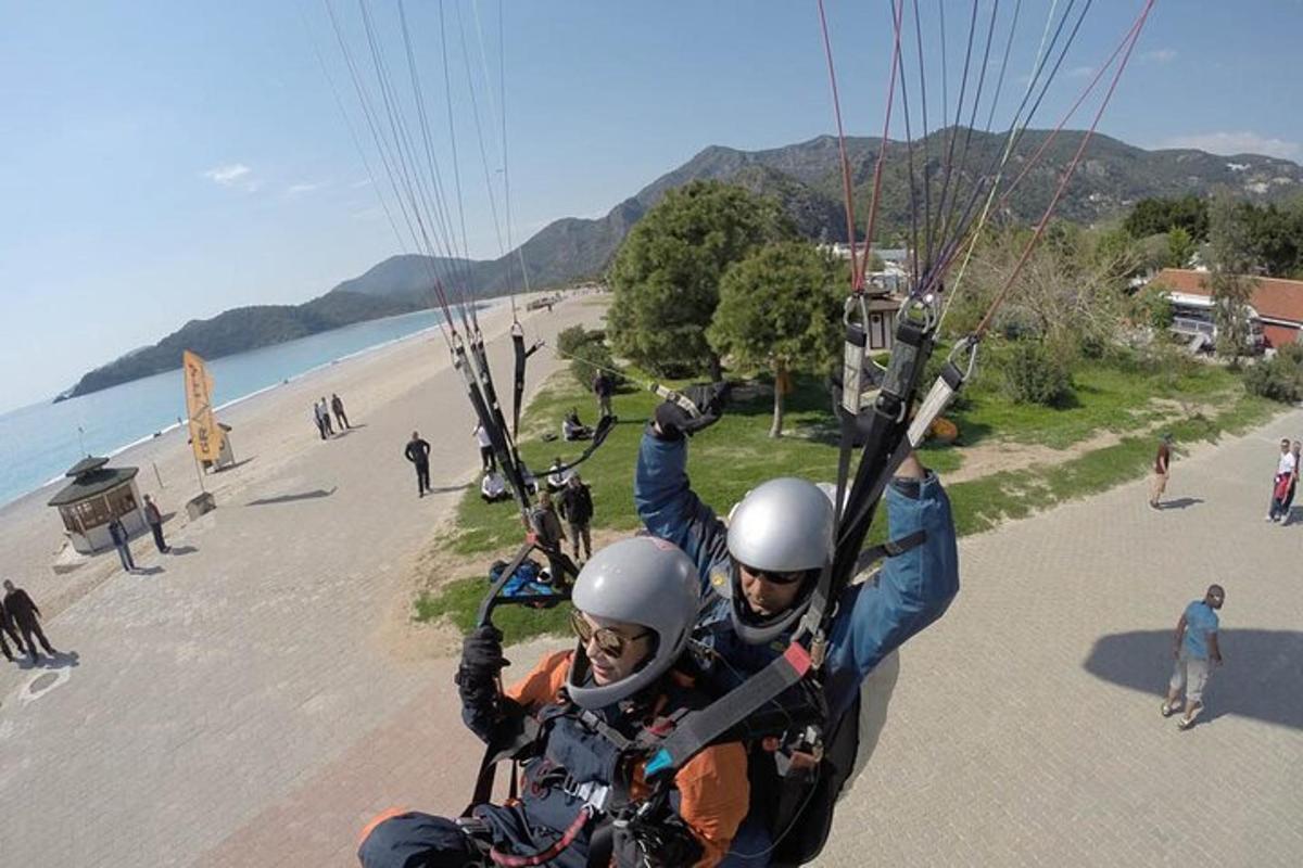 Dva lidé jedou na motorce na pláži
