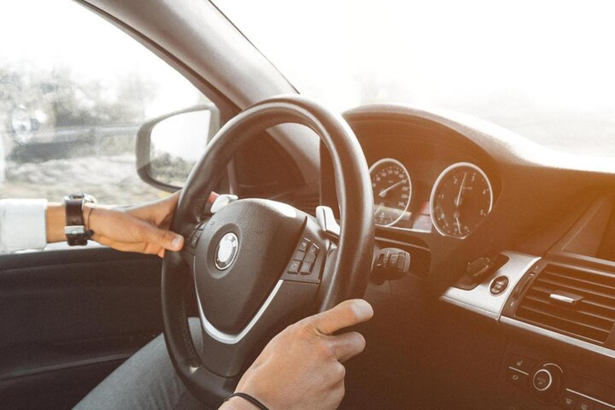 una persona che guida un'auto con un volante