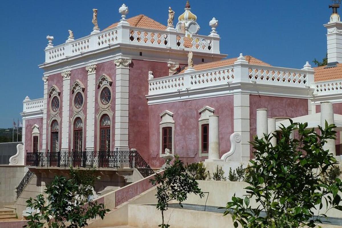 a large pink and white building with a balcony