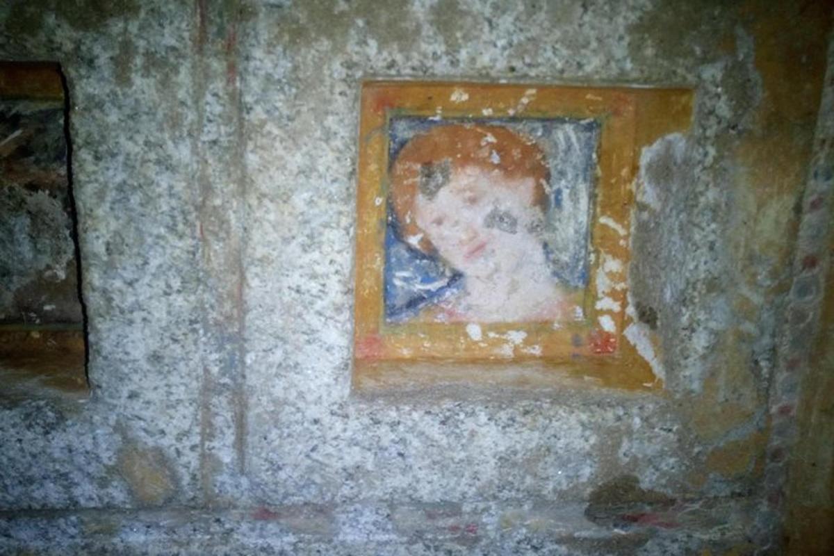 un dipinto di un bambino in una cornice su un muro
