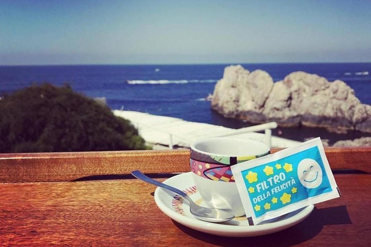 o ceașcă de cafea pe o farfurie pe un balcon cu oceanul