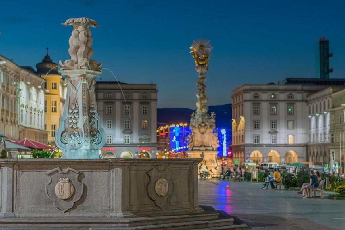 Una fuente en medio de una ciudad por la noche.