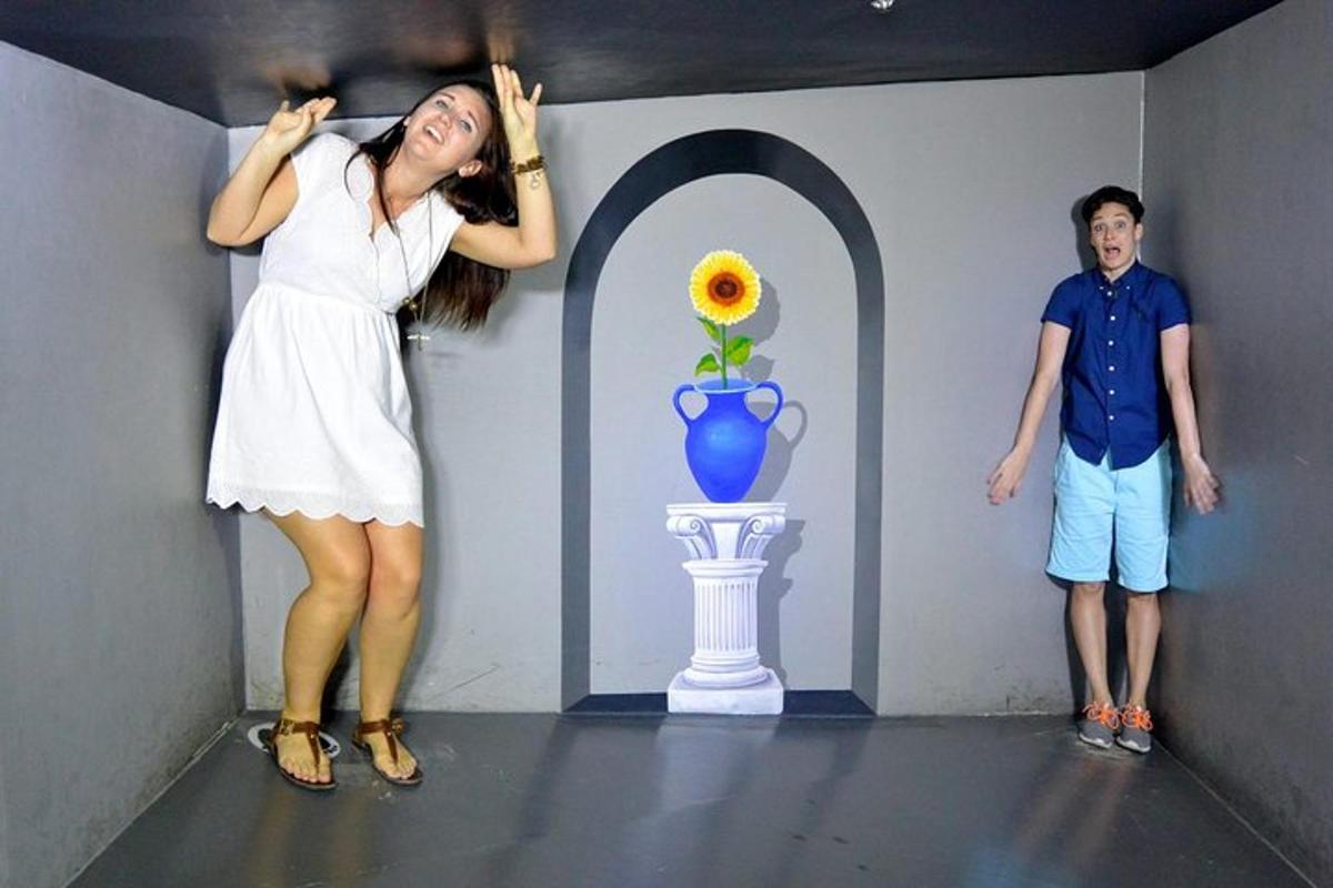 uma mulher e um homem em pé ao lado de uma pintura de um vaso