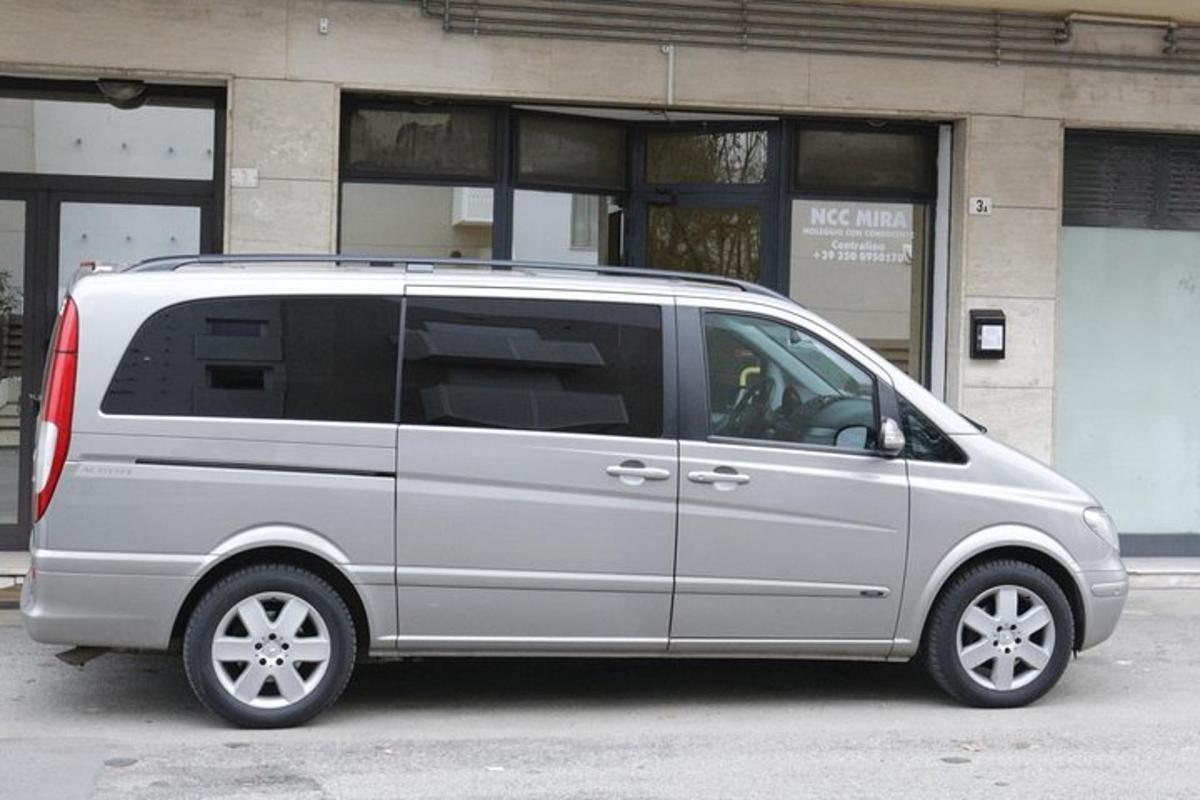 Una camioneta plateada estacionada frente a un edificio