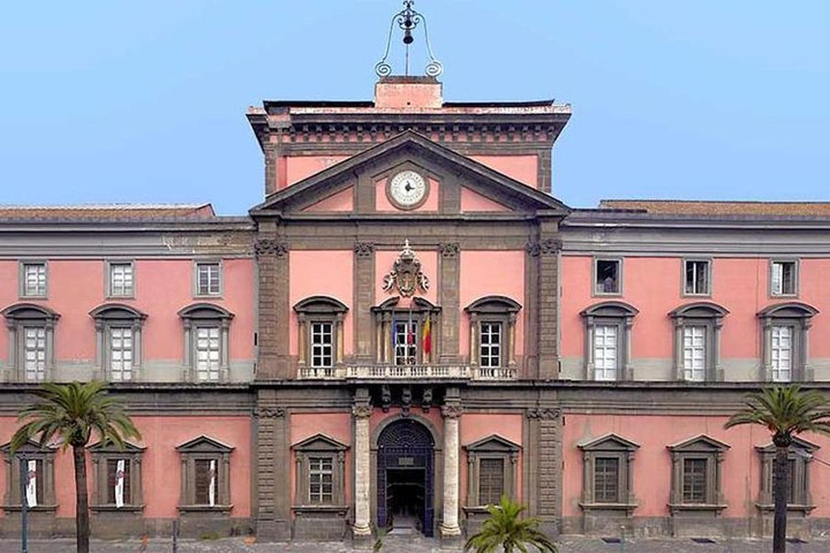 a large pink building with a clock on top of it