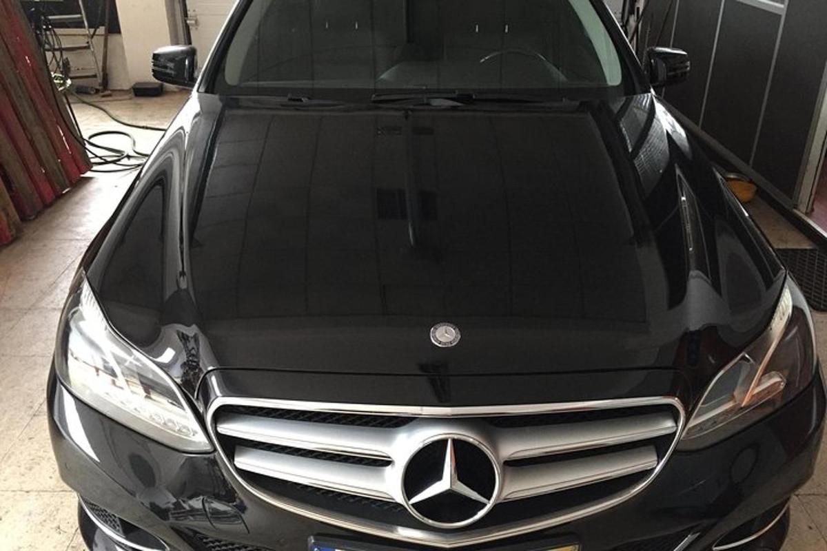 o mașină Mercedes-Benz neagră parcată într-un garaj