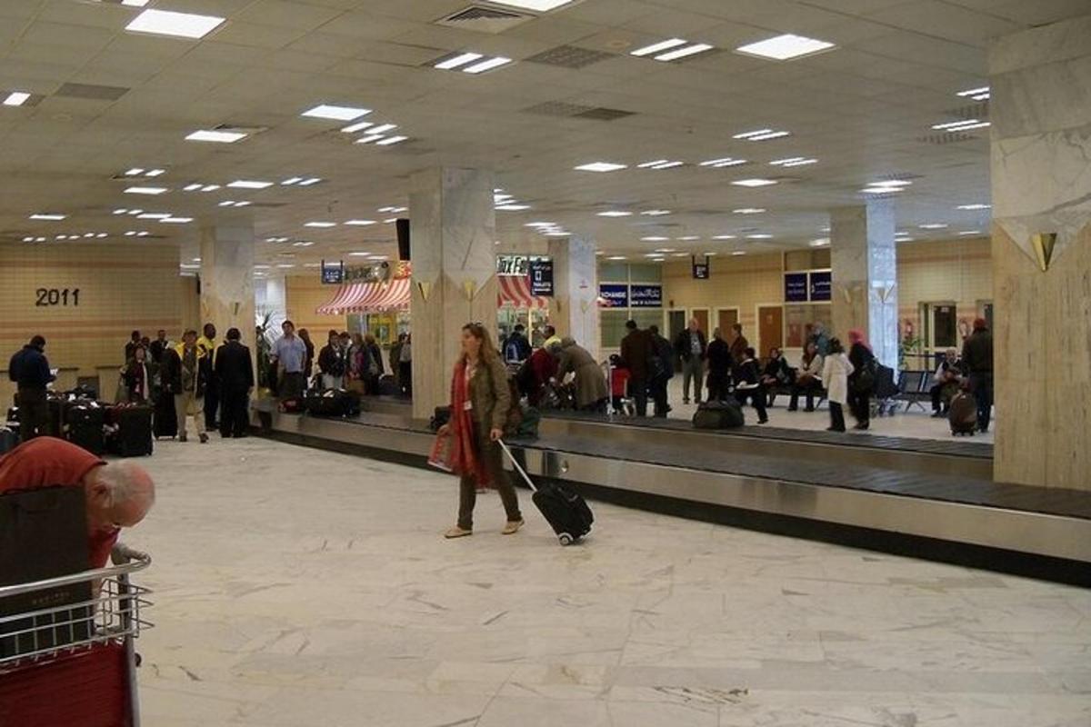 una dona caminant per un aeroport amb el seu equipatge