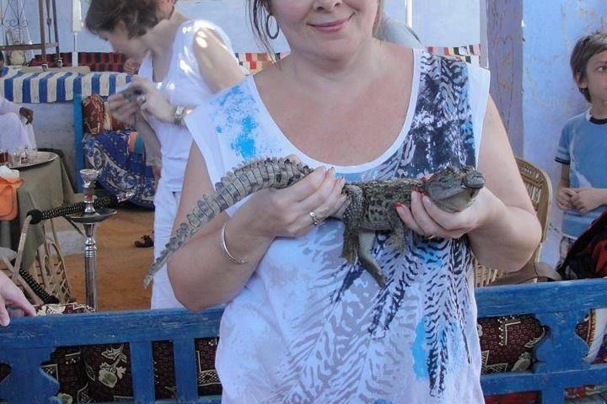 een vrouw die een hagedis in haar handen houdt
