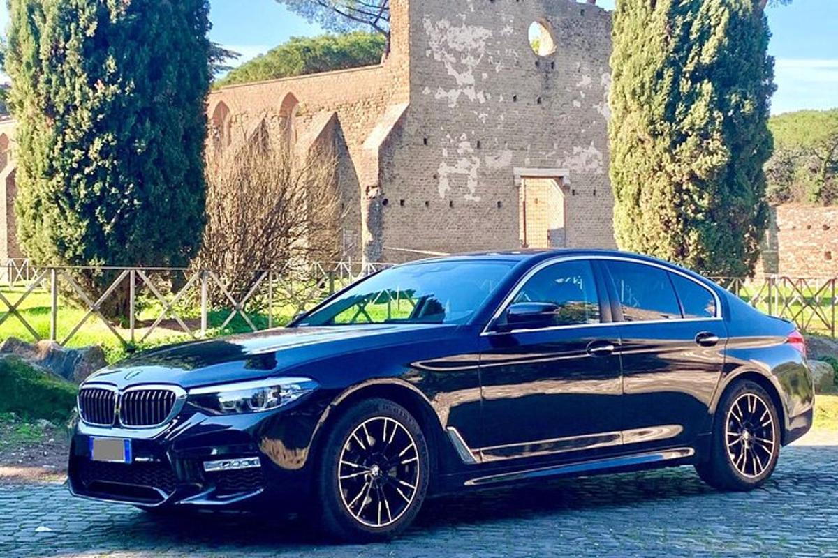 một chiếc xe bmw màu xanh đỗ trước một tòa nhà