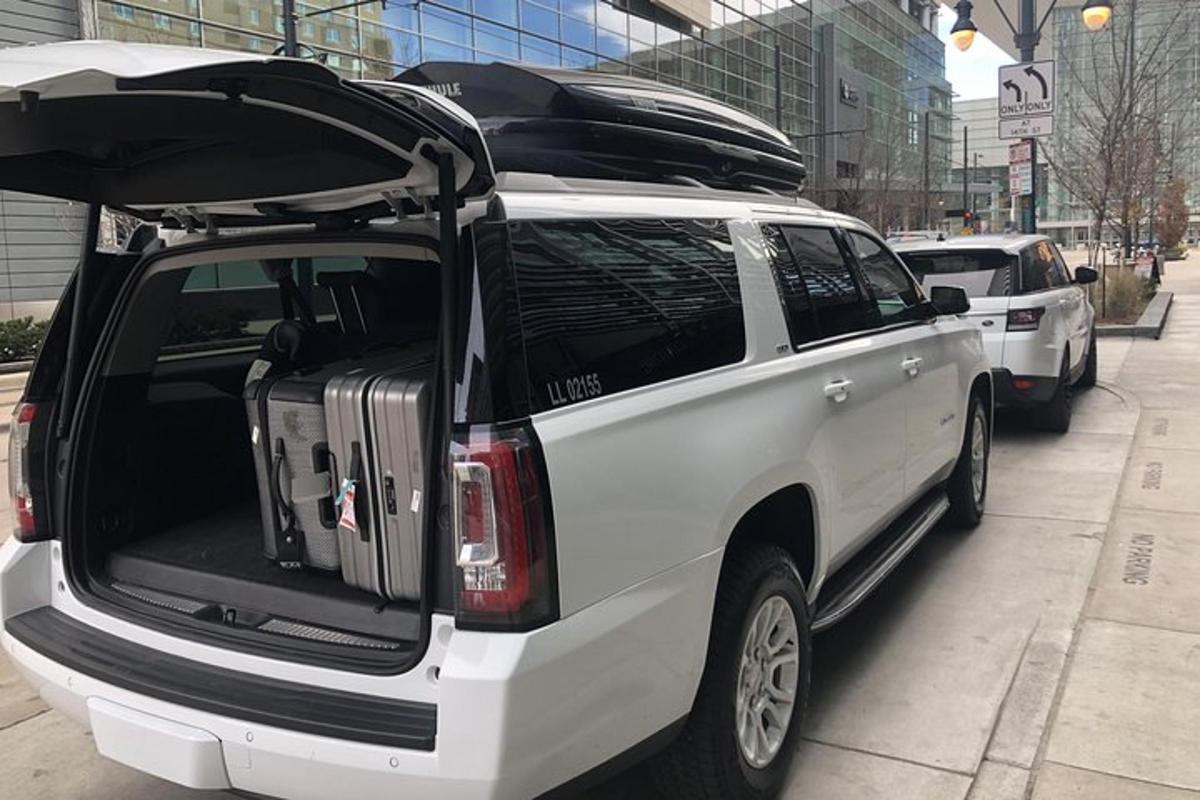 a white suv with its trunk open with luggage in it