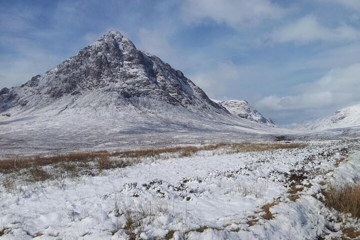 et fjell med snø på seg i et felt