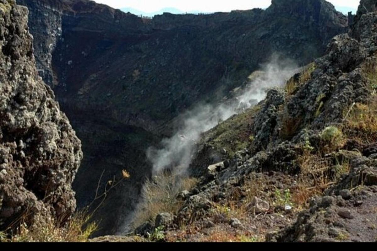 a view of a mountain with smoke in a valley