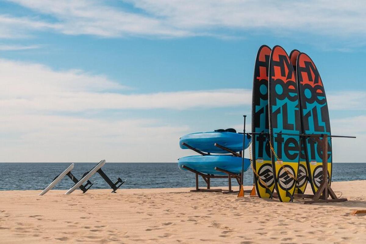 un paio di sedie e una tavola da surf sulla spiaggia