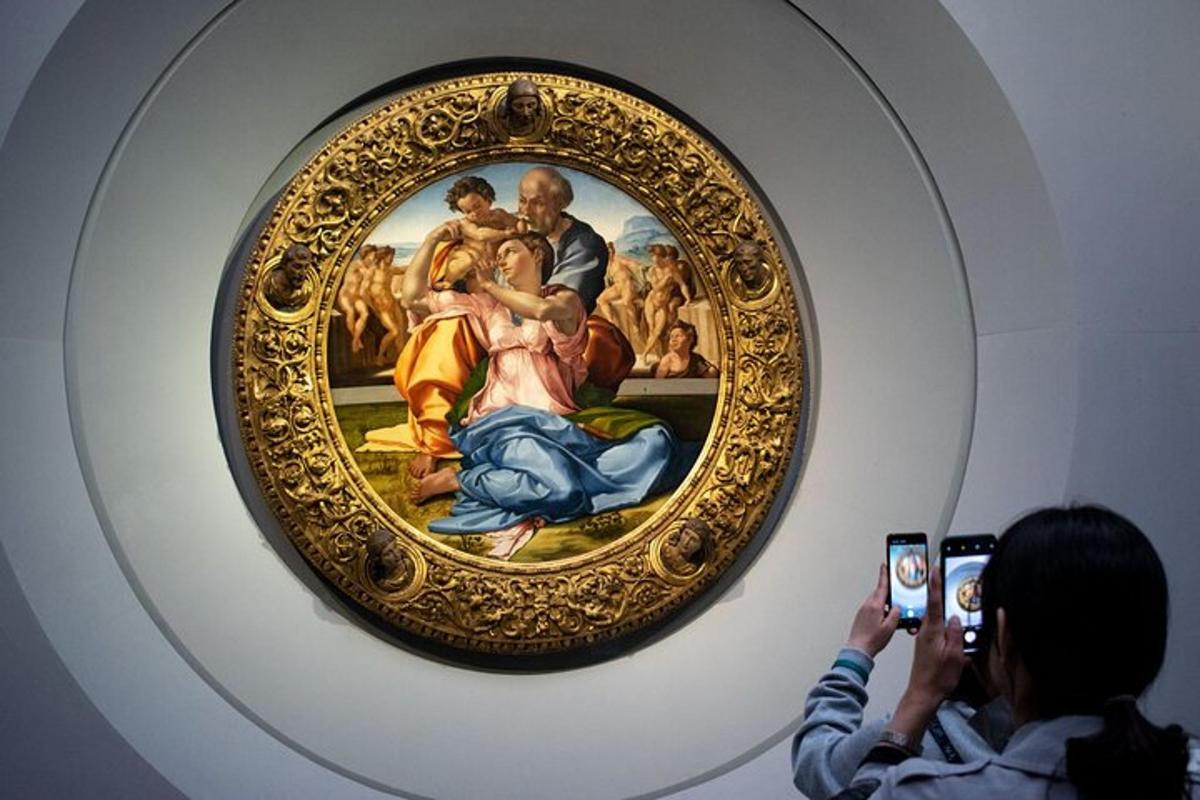 Una mujer tomando una fotografía de un cuadro en un museo.