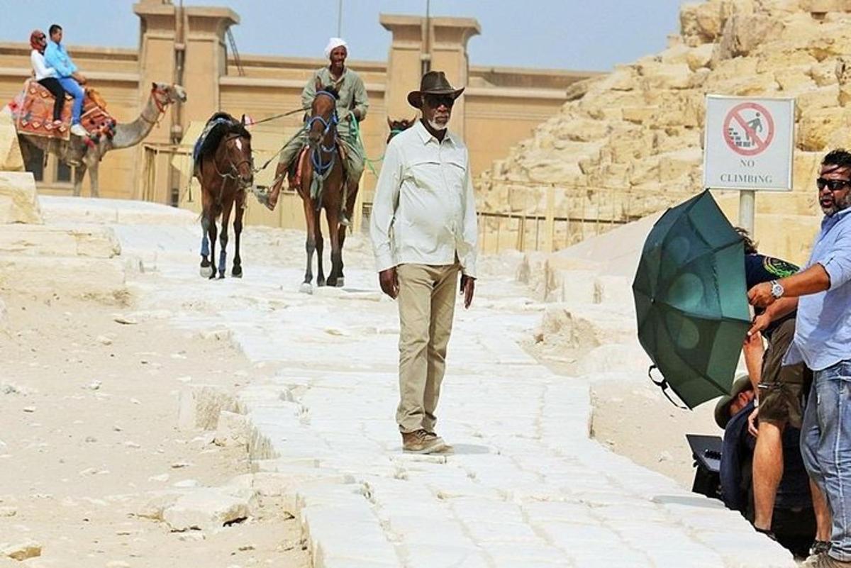 un uomo che cammina lungo una strada con cavalli e persone