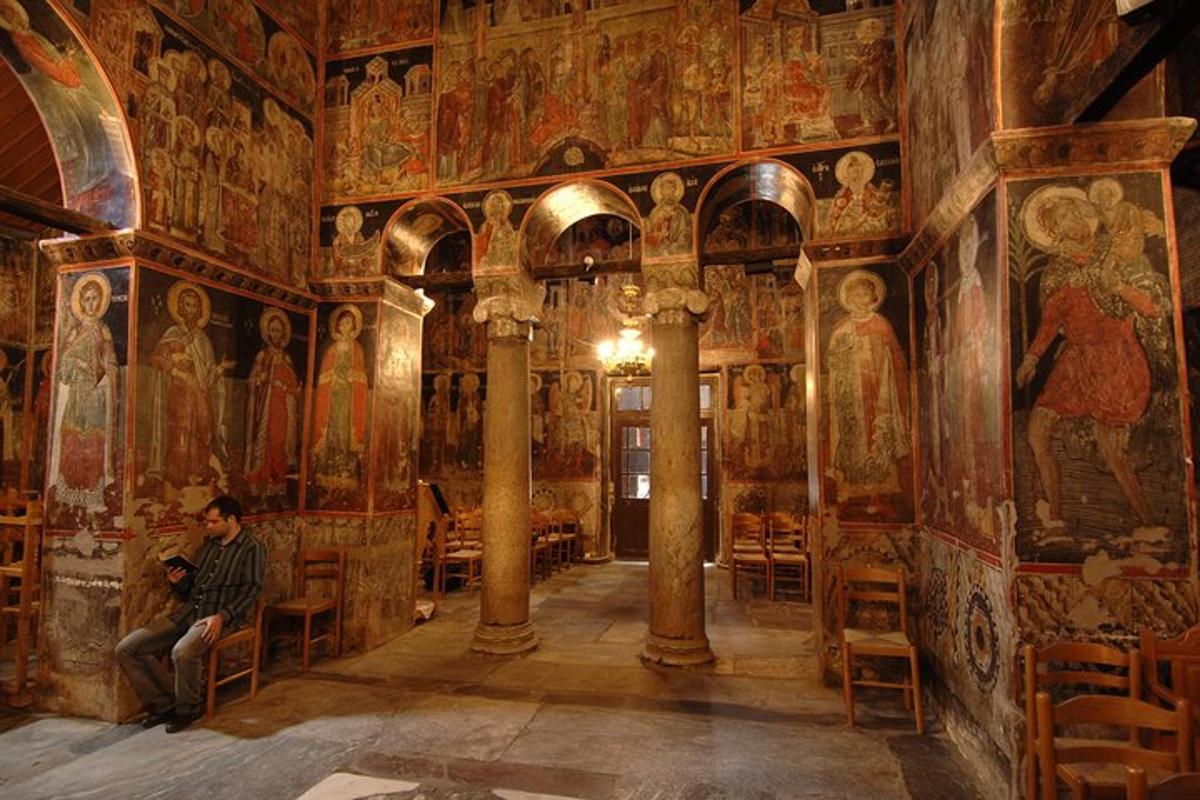 un uomo seduto in una chiesa con dipinti alle pareti