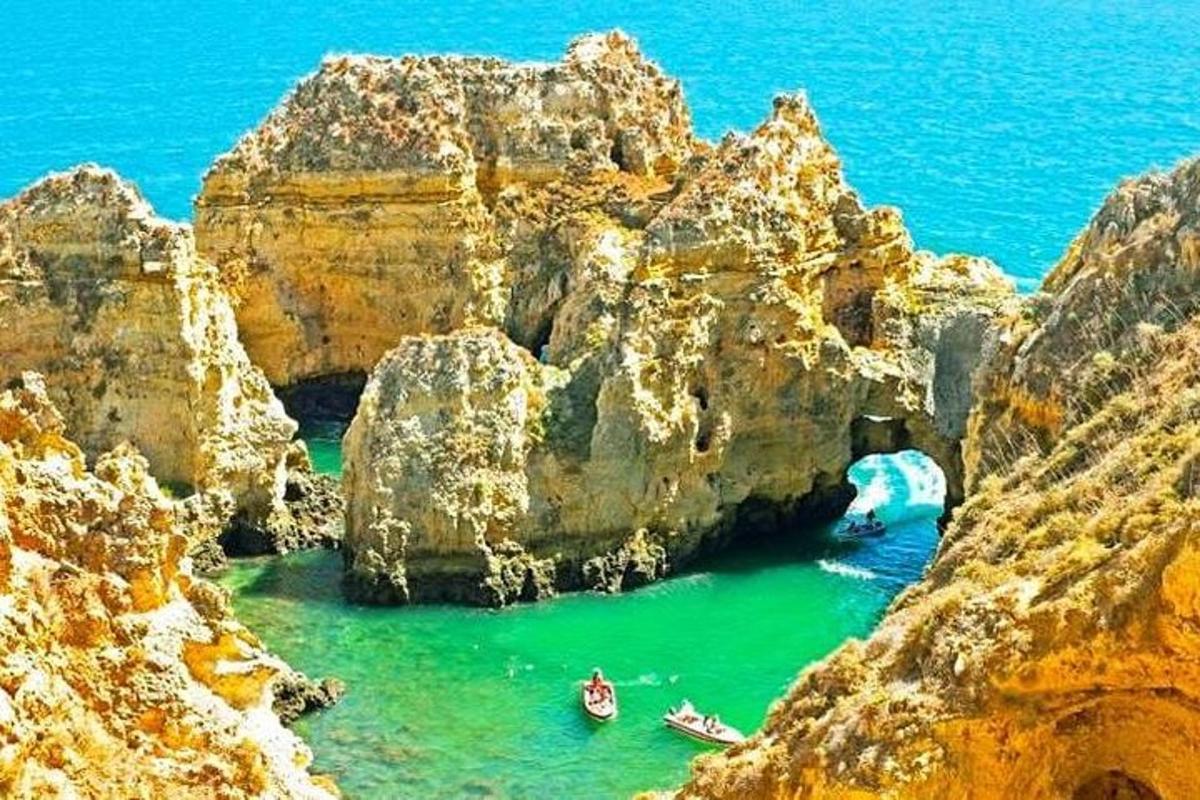 a cave in a mountain with boats in the water