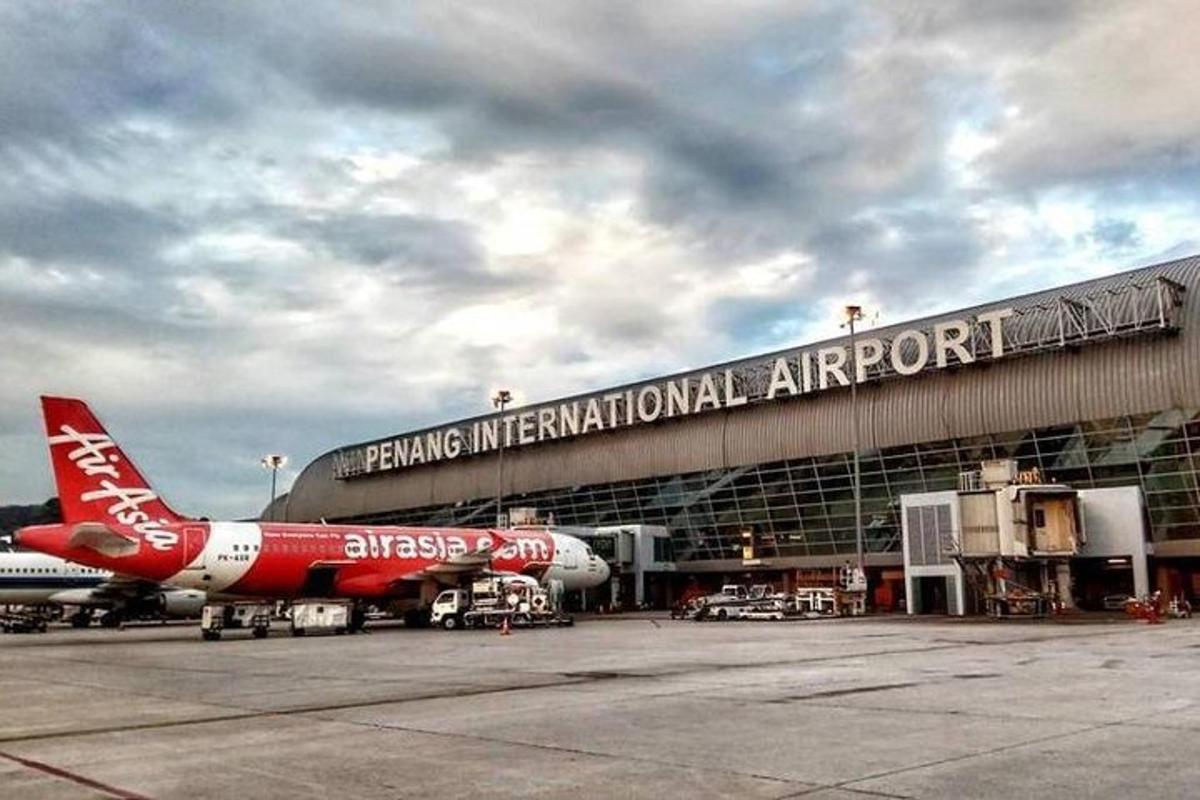 a red and white airplane parked at an airport