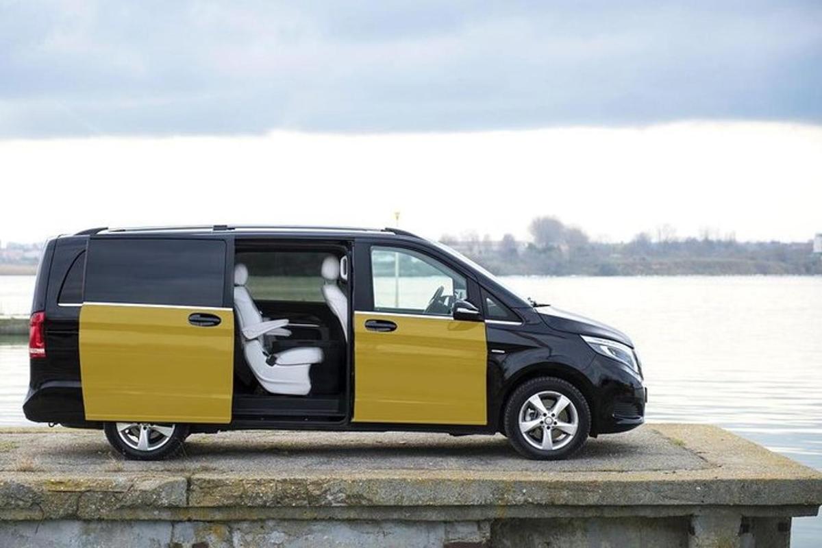 a black and yellow van parked next to a body of water
