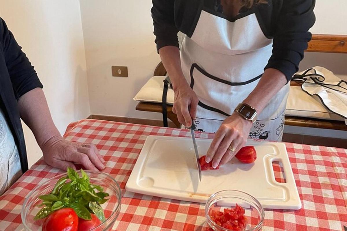 una persona che taglia un pomodoro su un tagliere