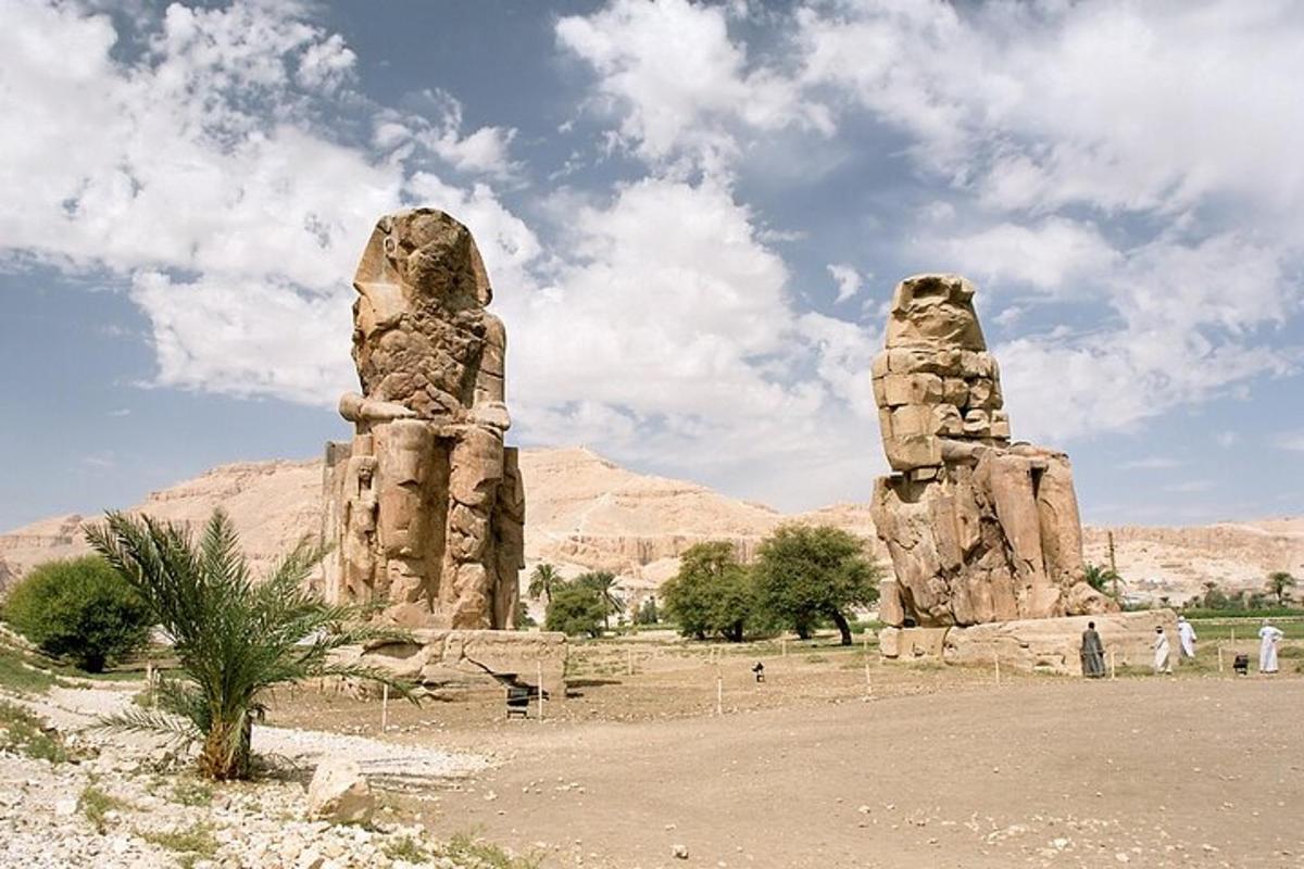 dues grans estàtues de pedra en un desert amb un cel