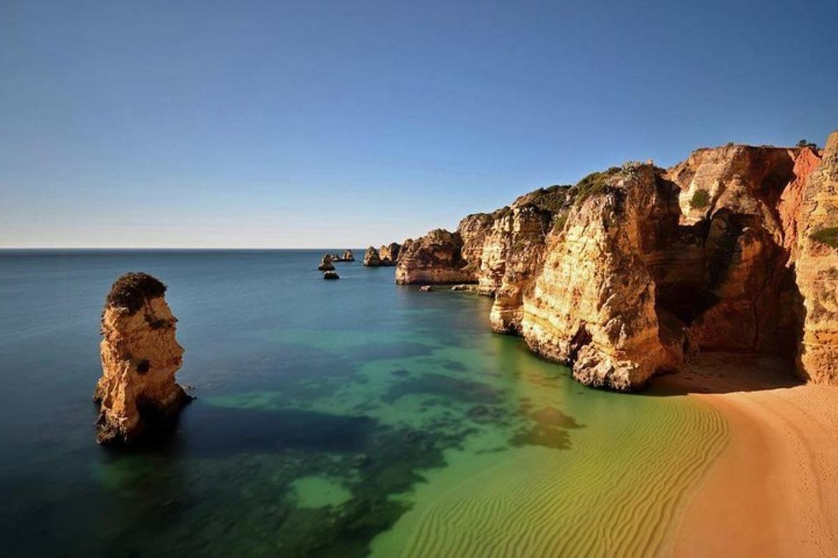 плажа са камењем у води поред песка
